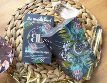 Load image into Gallery viewer, Meraki tarot 3rd edition front and back of box laying on a wicker mat amongst crystals on a wood background