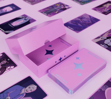 Load image into Gallery viewer, Exotic Cancer Tarot partially open box showing some cards. There is a stack of face down cards next to the box and the background is a grid formation of face up cards