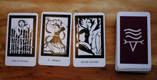Load image into Gallery viewer, Thea's tarot cards three cards lying face up in a row next to the rest of the stacked deck lying face down
