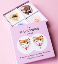 Load image into Gallery viewer, Open box of the Vulva Twins game with the cards showing inside the box all on a pink background