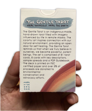 Load image into Gallery viewer, The Gentle Tarot linen edition with a hand holding the box and the back text of the box clearly readable all on a white background 
