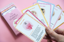 Load image into Gallery viewer, Hand holding a selection of cards fanned out showing the front of the cards. The box with a few cards showing slightly blurred in the background
