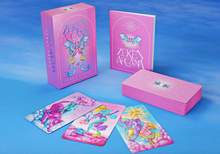 Load image into Gallery viewer, Zeke&#39;s Arcana box standing on end next to the guide booklet and the stacked card deck facedown. Three cards are facing up in front of the box. Everything is on a blue sky-like background

