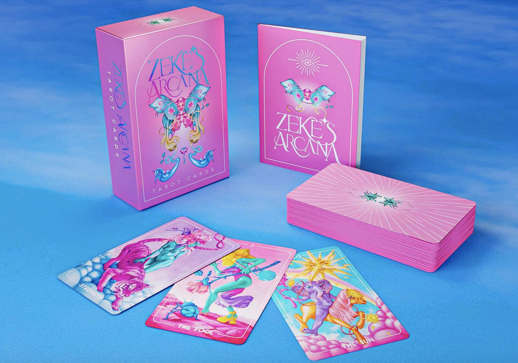 Zeke's Arcana box standing on end next to the guide booklet and the stacked card deck facedown. Three cards are facing up in front of the box. Everything is on a blue sky-like background